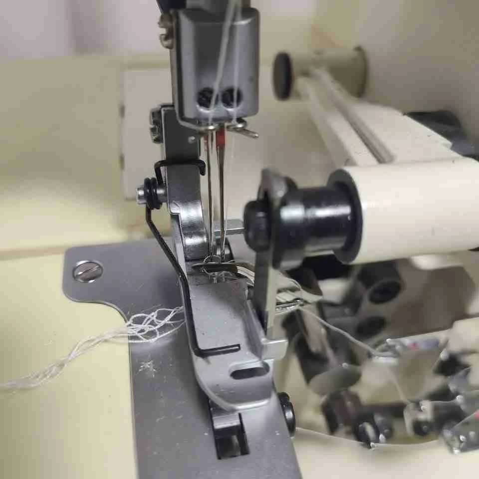 Serger needle and presser foot repair in Houston TX sewing machine workshop with technician tools